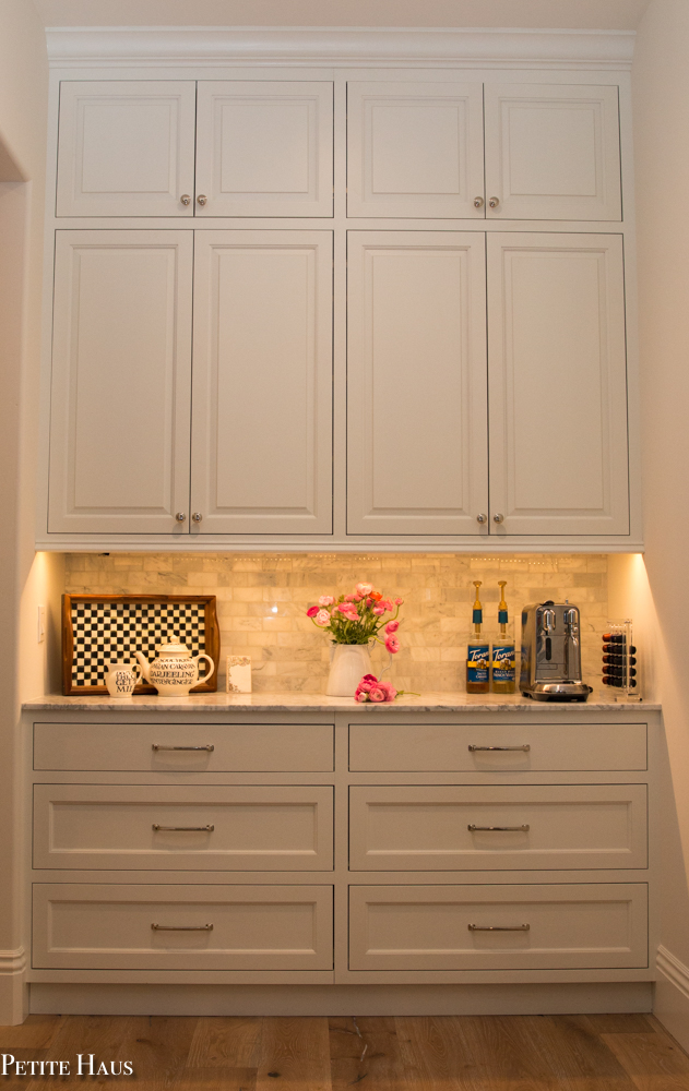 Coffee bar with farmhouse white kitchen cabinets and marble counters