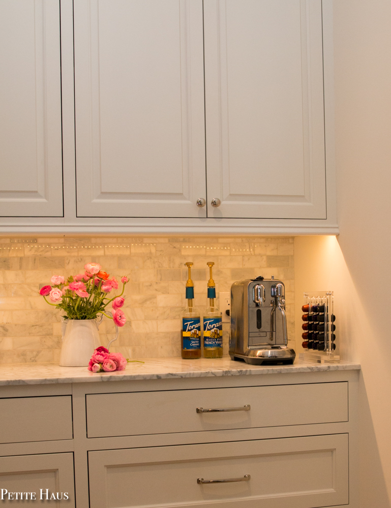 Coffee bar with farmhouse white kitchen cabinets and marble counters