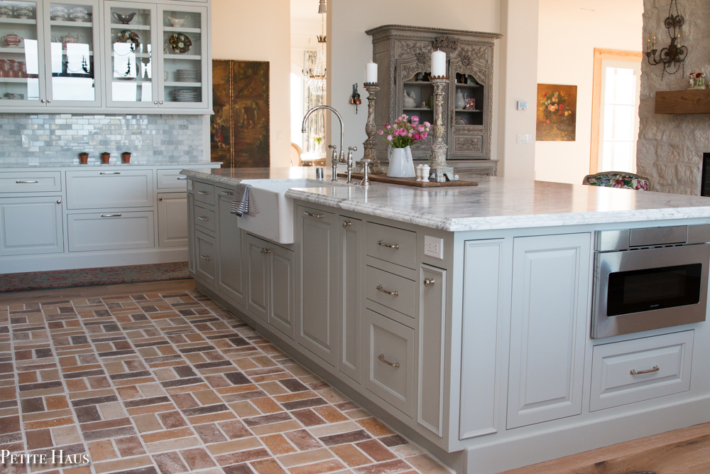 gray kitchen with brick floors and farm sink