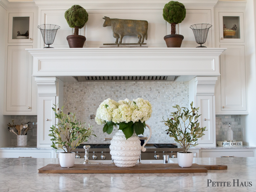 Farmhouse decor with faux olive tree topiaries and ironstone with white hydrangeas