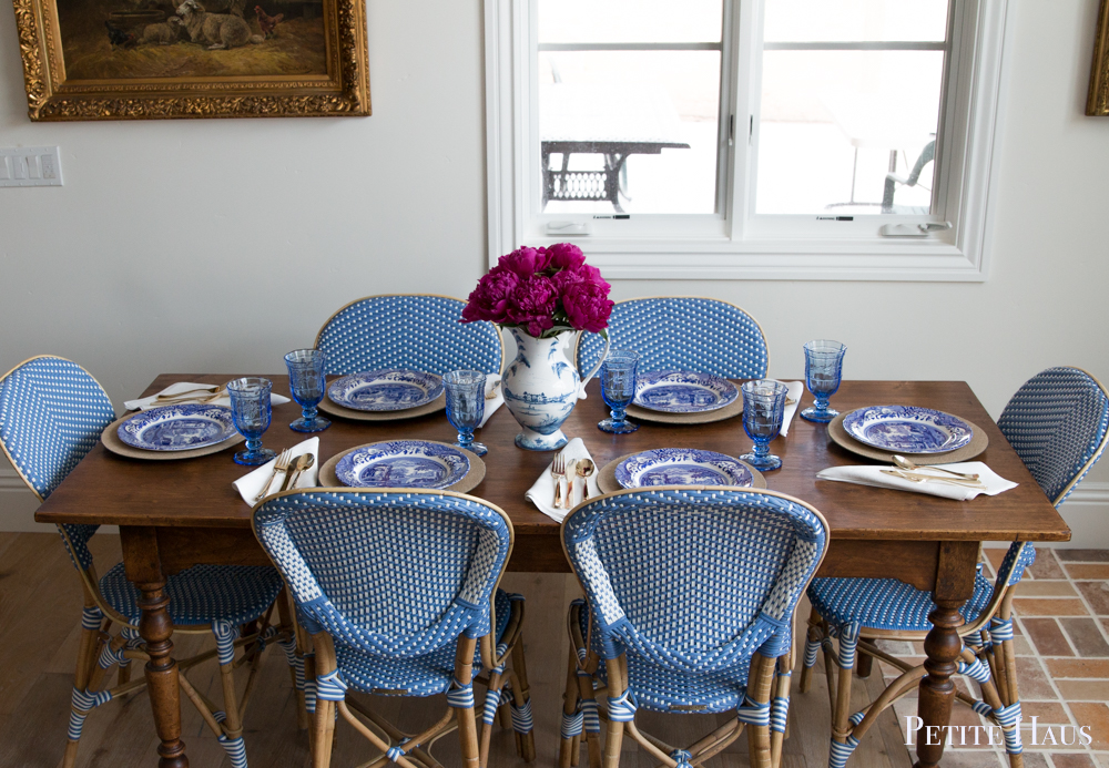 blue and white table setting with French bistro chairs and peonies