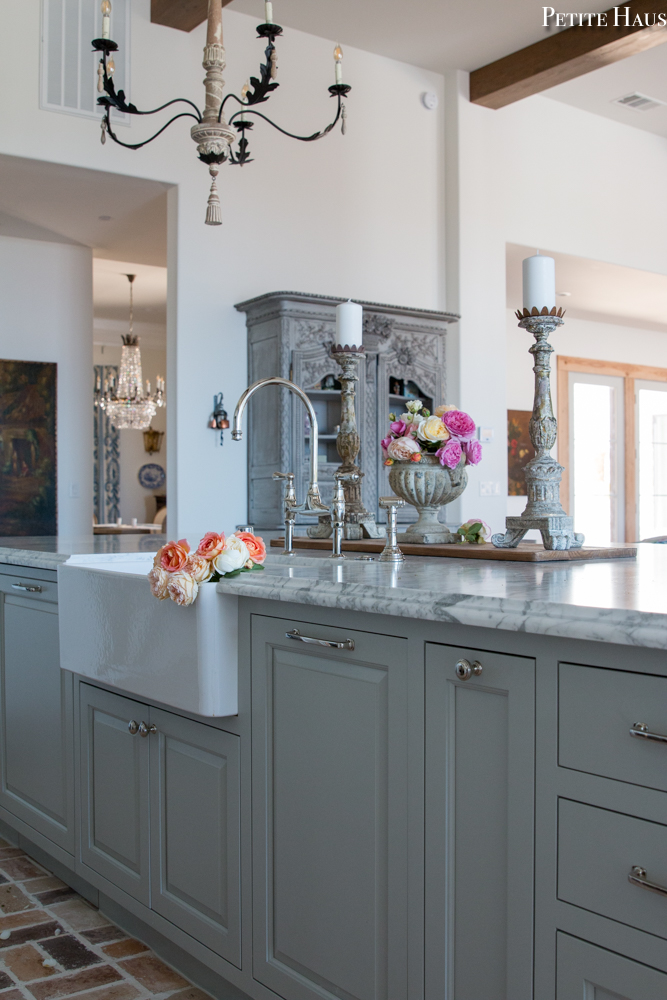 Lovely French country and French farmhouse style converge in a French kitchen by Petite Haus with island and farm sink. Island is  painted Benjamin Moore Silver Song.