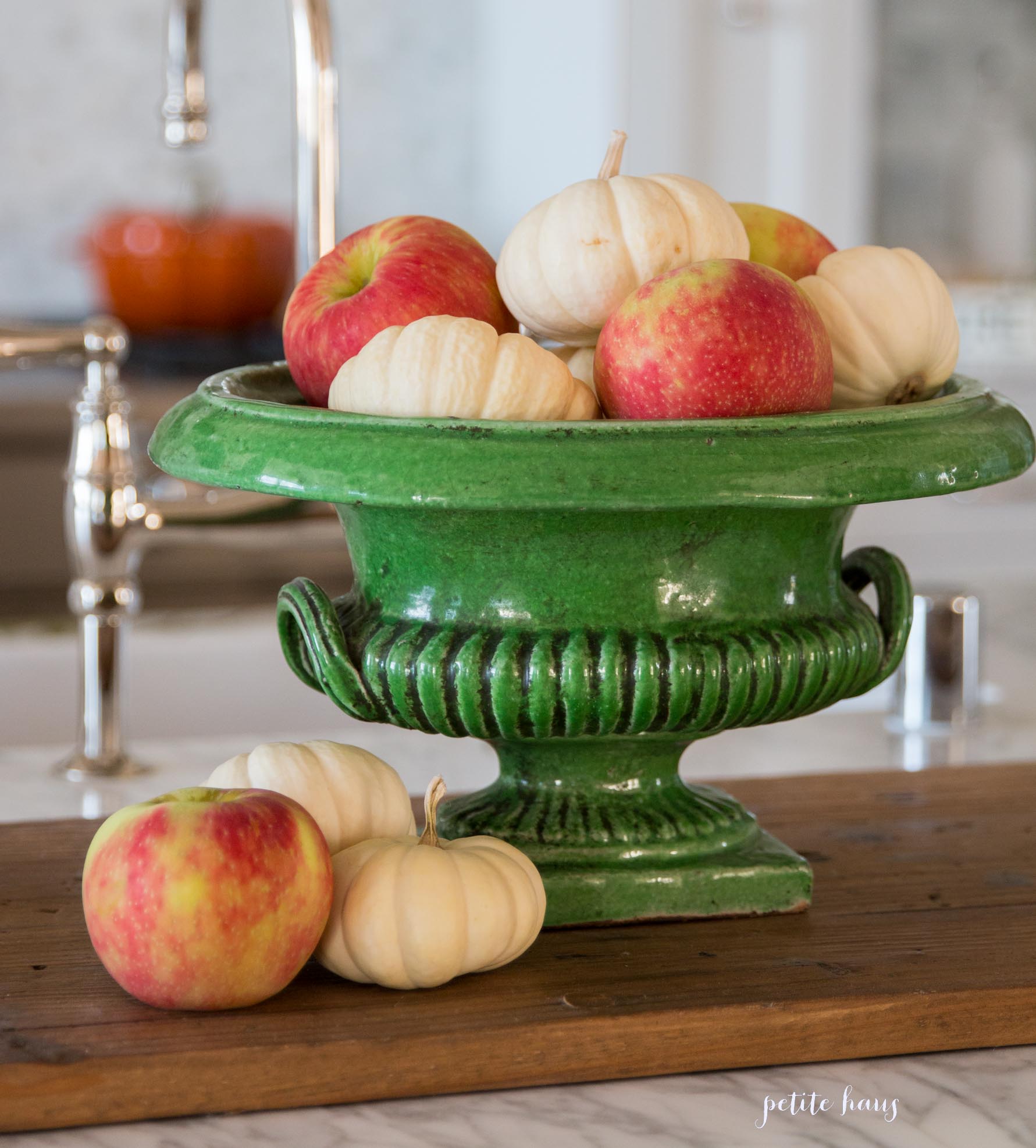apples and pumpkins in a majolica vase