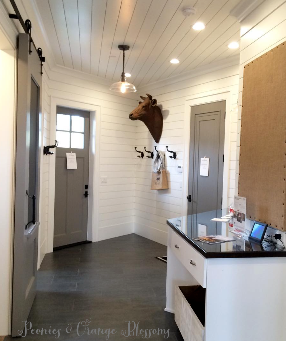 Touring a French farmhouse - a mudroom with shiplap walls, grey doors, and country touches