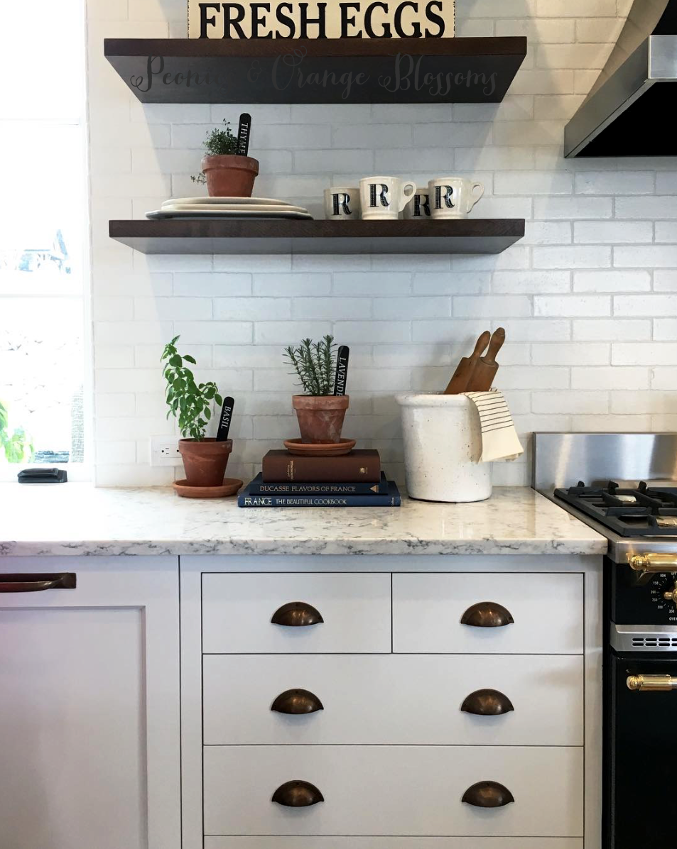 Touring a French farmhouse with open shelving and brass hardware in the kitchen